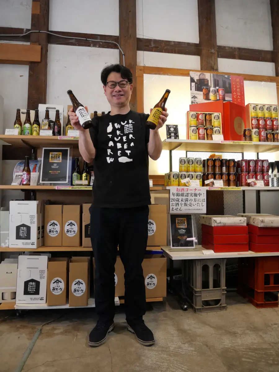 いわて蔵ビールの商品を両手に持つ弊社代表の佐藤航