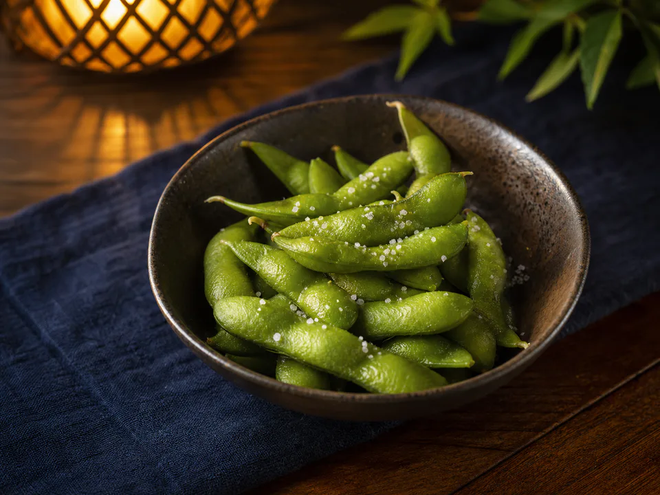 藍色の布を敷いた夏の食卓に盛り付けた塩ゆで枝豆
